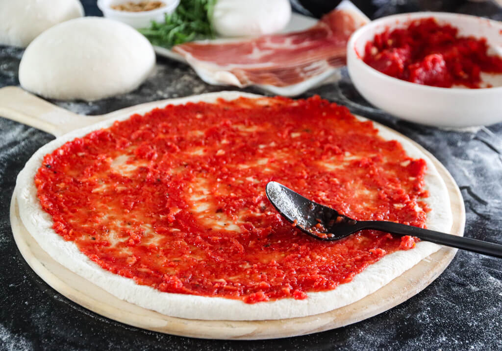 Italiensk pizza med tomatsaus og parmaskinke