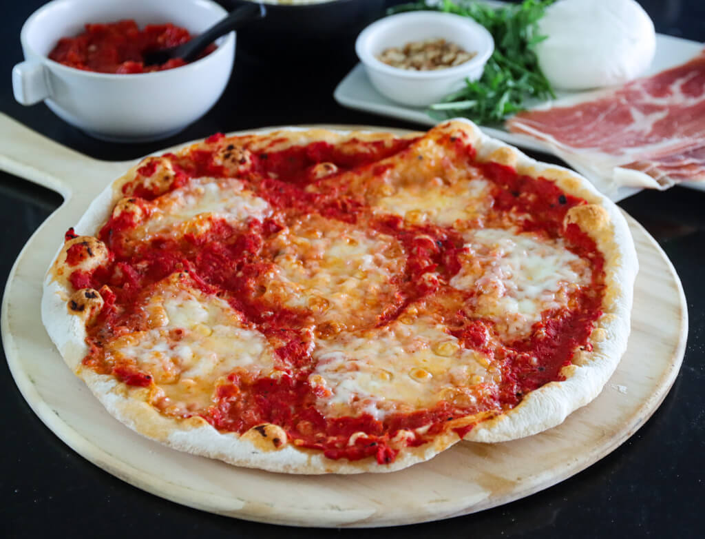 Italiensk pizza med tomatsaus og parmaskinke