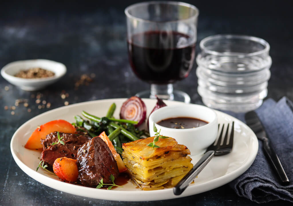 Reinsdyrfilet med rødvinssaus, plommer og Annapoteter